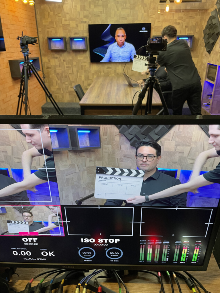 Bastidores da gravação do Vibbracast, com Leandro Oliveira, da Vibbra, no estúdio e Joás Andrade participando remotamente pela tela.